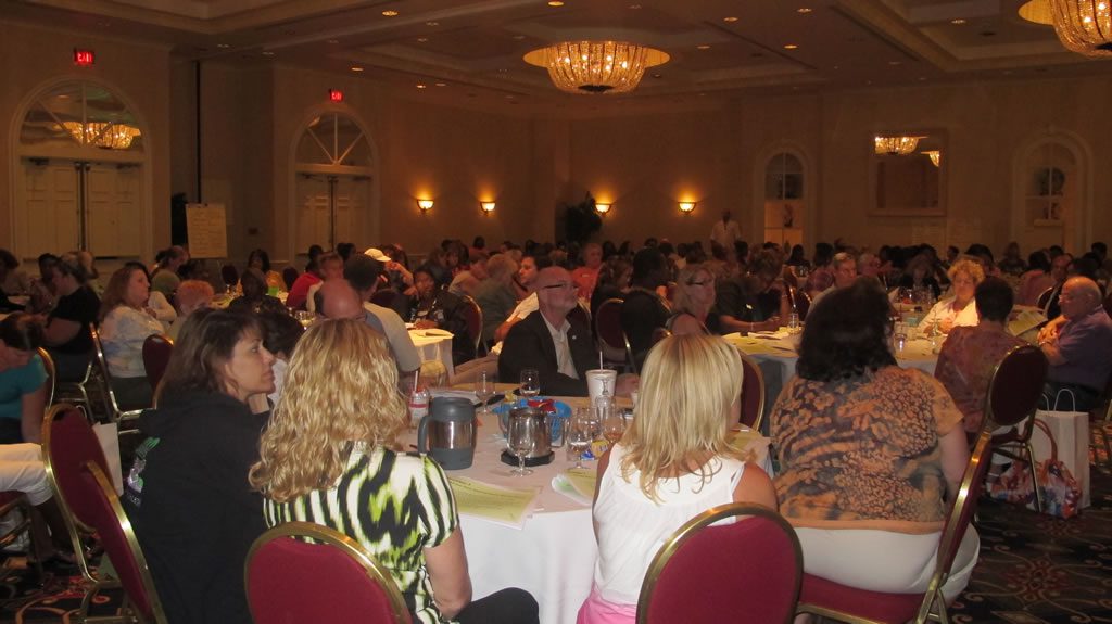 Hall full of tables of people at annual conference