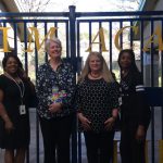 4 women in front of school gates
