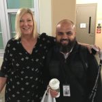 Women with arm around man, both wearing black