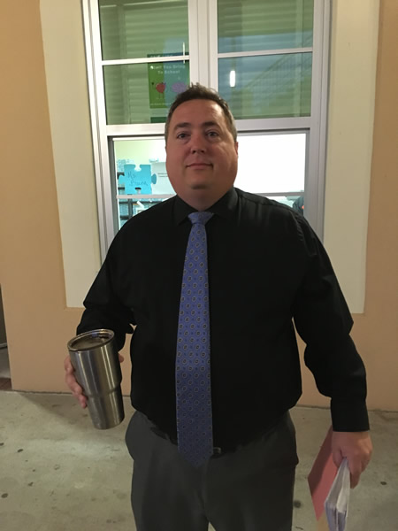Man in blue tie and black shirt
