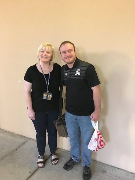 Man and lady wearing black in front of yellow wall