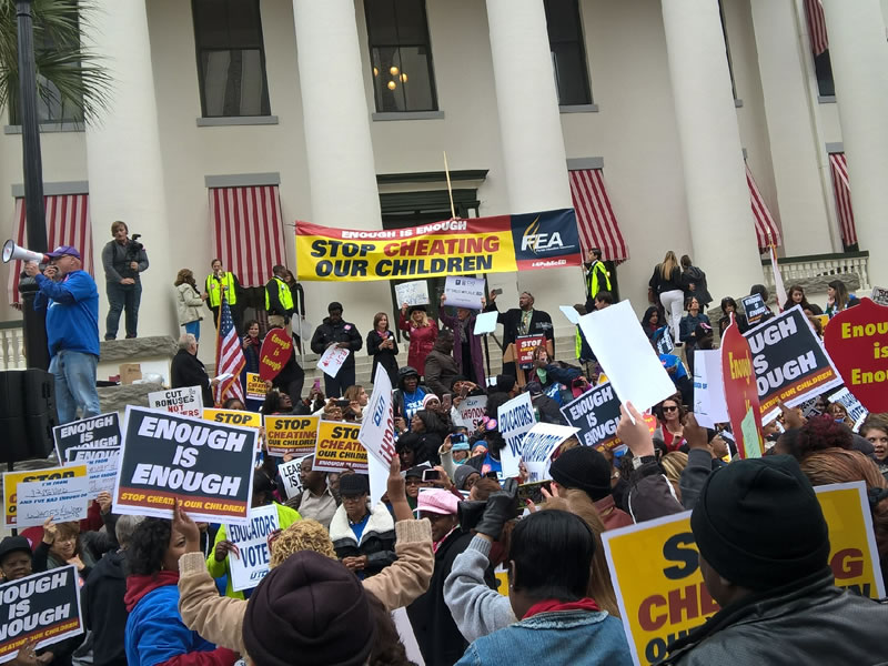Lots of signs being held by people at rally