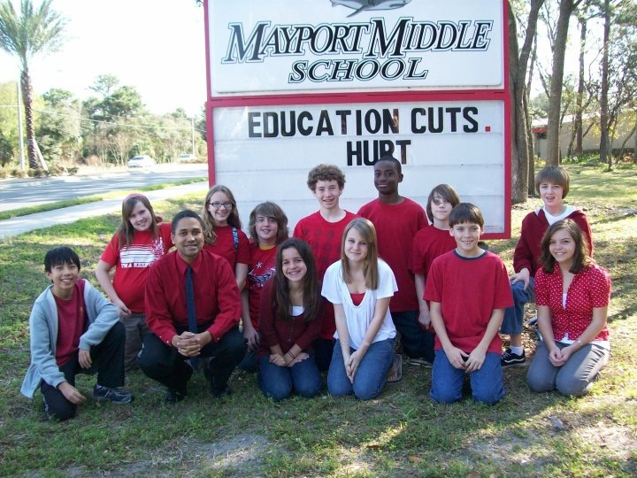 John Meeks and students in front of Mayport Middle School sign