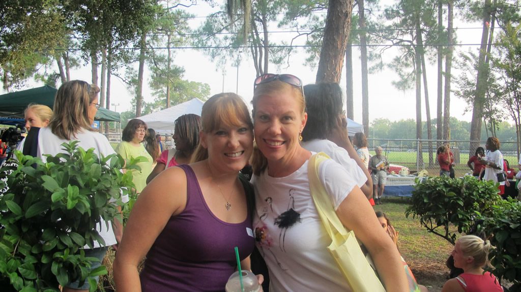 Lady in purple and lady in white shirt hugging