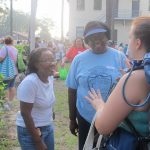Two ladies talking with lady wearing camping backpack